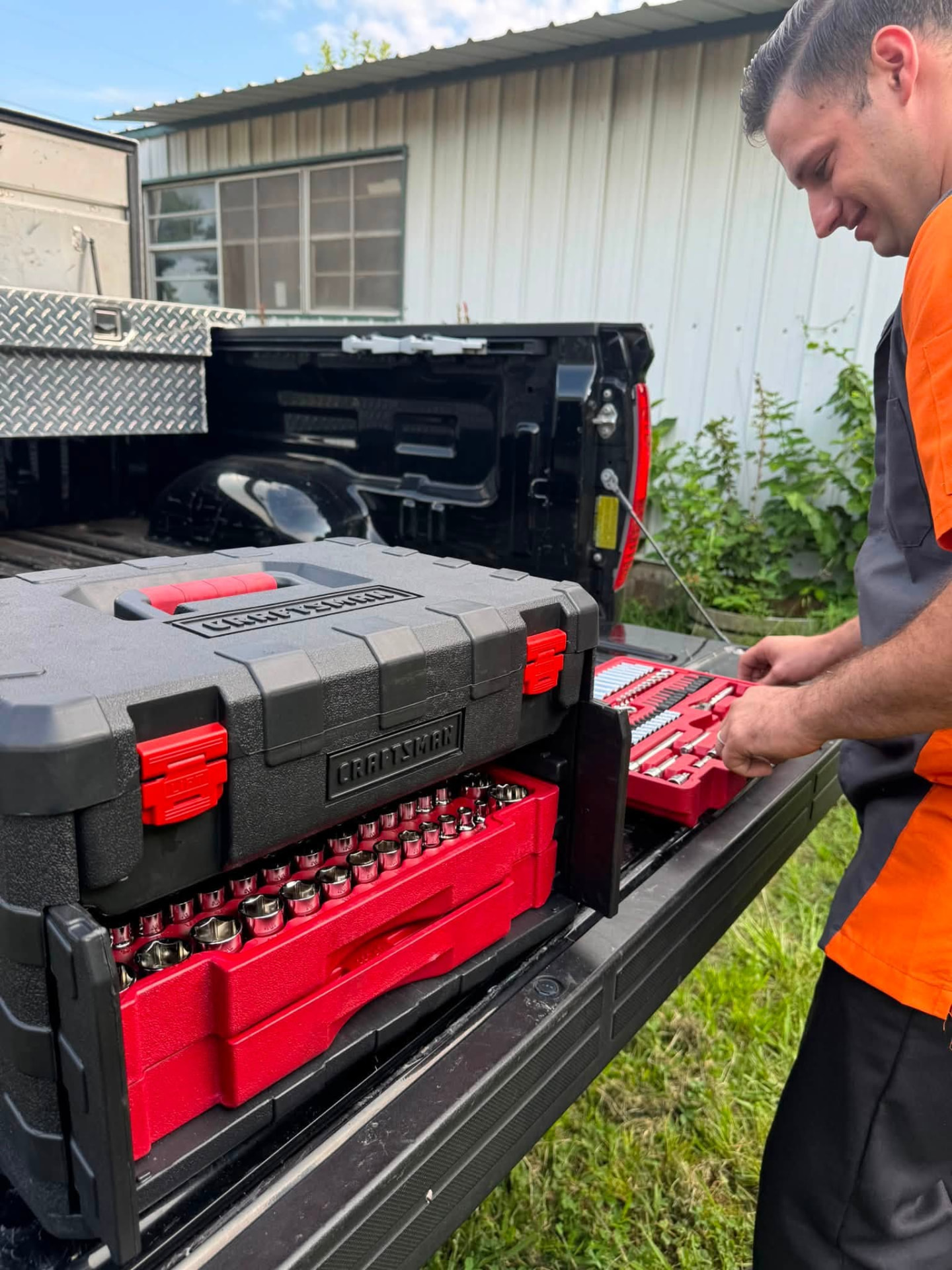 Jacob laying out professional socket and tool sets on his truck tailgate